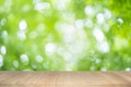 Empty wooden table on green nature background with beauty bokeh under sunlight Royalty Free Stock Photo