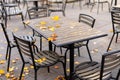Empty wooden table in the outdoor autumn cafe with metallic black chairs Royalty Free Stock Photo