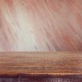 Empty wooden table over painted marsala color wall