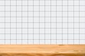 Empty wooden table over square ceramic tile background. Royalty Free Stock Photo