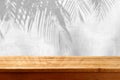 Empty wooden table over stone wall with palm tree shadow background. Outdoor tabletop for mock up design and product display Royalty Free Stock Photo