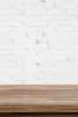Empty wooden table over white brick wall background, for produc Royalty Free Stock Photo
