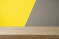 Empty wooden table over yellow and gray background. Modern and trendy interior mock up