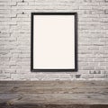 Empty wooden table with poster mock up template over brick wall Royalty Free Stock Photo