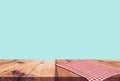 Empty wooden table with red checked tablecloth over blue wall background Royalty Free Stock Photo