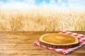 Empty Wooden Table With Tablecloth And Wooden Board Over Wheat Field  Background. Harvest Mock Up For Design