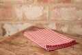 Empty wooden table with tablecloth over brick stone wall background Royalty Free Stock Photo