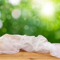 Empty wooden table with a tablecloth over green bokeh background Royalty Free Stock Photo