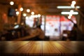 Empty wooden table top with blurred coffee shop or restaurant interior background. Abstract background can be used for display Royalty Free Stock Photo