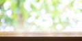 Empty wooden table top with blurred green garden background. Pan