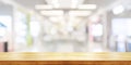 Empty wooden table top with blurred modern shopping mall background. Panoramic banner