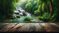 empty wooden table top foregrounds jungle landscape, complete with waterfall