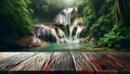 empty wooden table top foregrounds jungle landscape, complete with waterfall