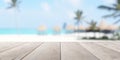 Empty wooden table top with out of focus lights bokeh tropical ocean beach background with palm trees and cabins