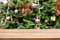 Empty wooden table top over Defocused of decorated Christmas tree with toys, gift box, lights, bauble inside the office building. Royalty Free Stock Photo