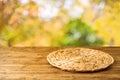 Empty wooden table with wicker round placemat over autumn nature park background Royalty Free Stock Photo