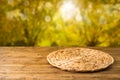 Empty wooden table with wicker round placemat over autumn nature park background Royalty Free Stock Photo