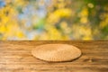 Empty wooden table with wicker round placemat over autumn nature park background Royalty Free Stock Photo