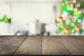 Empty wooden tabletop for display products and blurred kitchen with Christmas tree as background. Royalty Free Stock Photo