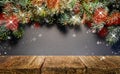 Empty wooden tabletop for presentation of goods on a Christmas festive background of fir branches and lights. Royalty Free Stock Photo