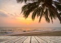 Wooden terrace over tropical island beach with coconut palm at sunset or sunrise time Royalty Free Stock Photo