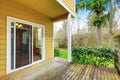 Empty wooden walkout deck, backyard view of yellow house Royalty Free Stock Photo