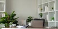 Empty workplace with desk and plant in office room, copy space. work from an atmospheric home office full of green plant Royalty Free Stock Photo