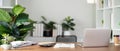 Empty workplace with desk and plant in office room, copy space. work from an atmospheric home office full of green plant Royalty Free Stock Photo