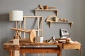 Empty workspace of carpenter: table with tools, wooden chair, lamp, shelf on the background, empty joinery Royalty Free Stock Photo