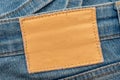 Empty worn leather patch on blue jeans. Empty space for writing. Blank leather jeans label Royalty Free Stock Photo