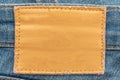 Empty worn leather patch on blue jeans. Empty space for writing. Blank leather jeans label Royalty Free Stock Photo