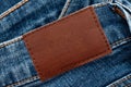 Empty worn leather patch on blue jeans. Empty space for writing. Blank leather jeans label Royalty Free Stock Photo