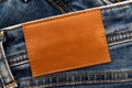 Empty worn leather patch on blue jeans. Empty space for writing. Blank leather jeans label Royalty Free Stock Photo