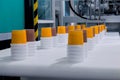 Empty yellow and brown plastic cups moving on conveyor belt at exhibition