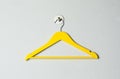 Empty yellow clothes hanger on white wall Royalty Free Stock Photo