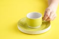 Empty yellow coffee or tea cup on yellow background. Royalty Free Stock Photo