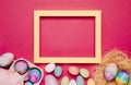 empty yellow frame with colorful easter eggs pink background. High quality photo Royalty Free Stock Photo