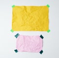 Empty yellow and pink crumpled sheets of paper glued with green sticky pieces Royalty Free Stock Photo