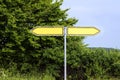 Empty yellow road signs pointing in opposite directions against