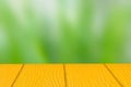 Empty yellow wooden table on green nature blurry background, copy space for your text. Montage product display Royalty Free Stock Photo