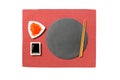 Emptyround black slate plate with chopsticks for sushi, ginger and soy sauce on red napkin background. Top view with copy space Royalty Free Stock Photo