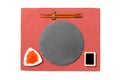 Emptyround black slate plate with chopsticks for sushi, ginger and soy sauce on red napkin background. Top view with copy space Royalty Free Stock Photo