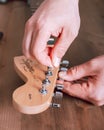 EMPURIABRAVA, SPAIN - FEBRUARY 17, 2021 Guitar master changing guitar strings on Fender Squier Strat, top view Royalty Free Stock Photo