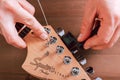 EMPURIABRAVA, SPAIN - FEBRUARY 17, 2021 Guitar master changing guitar strings on Fender Squier Strat