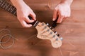 EMPURIABRAVA, SPAIN - FEBRUARY 17, 2021 Guitar master changing guitar strings on Fender Squier Strat
