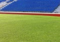 The empy green field and blue seats at the stadium