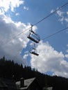 Empy rope way seats over mountain village at summer time