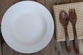 Empy white plate with fork lay on wooden table