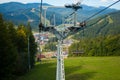 Emtpy chairlift in ski resort. Mountains and hills with in Summer with green trees Royalty Free Stock Photo