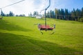 Emtpy chairlift in ski resort. Mountains and hills with in Summer with green trees Royalty Free Stock Photo